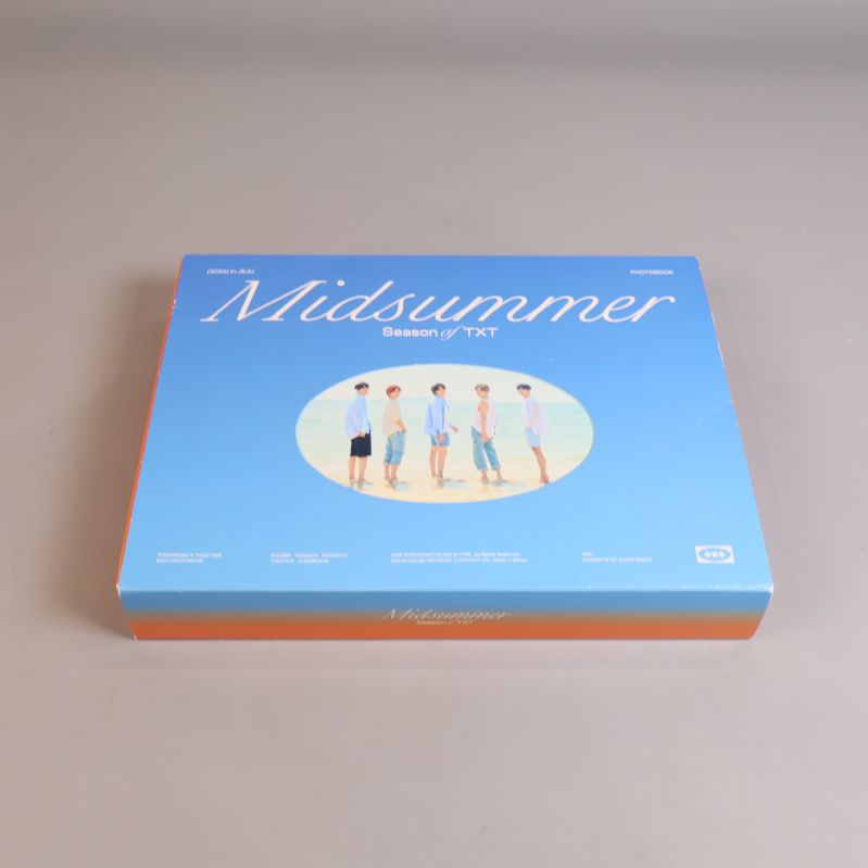 Framsida av stor blå box med Midsummer och TXT på omslaget
