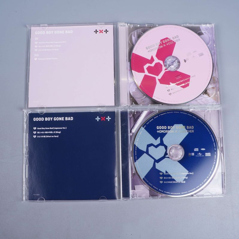 Öppnade CD-fodral visar rosa och blå skivor samt inneromslag