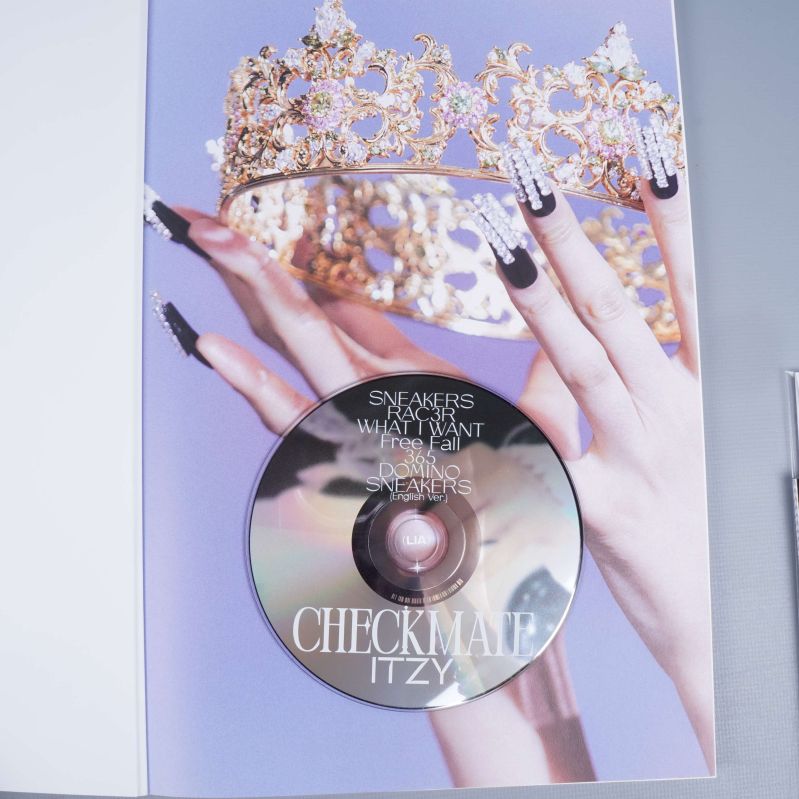 Närbild på CD-skiva och krona i ITZY Checkmate-albumet