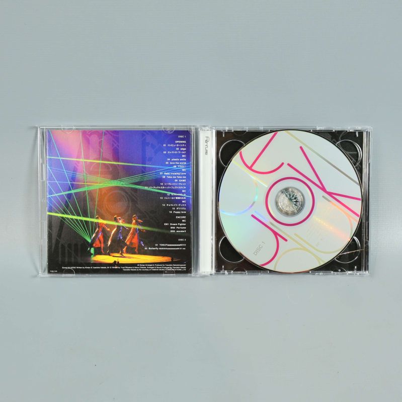 CD-fodral öppnat visar färgglad skiva och konsertbild