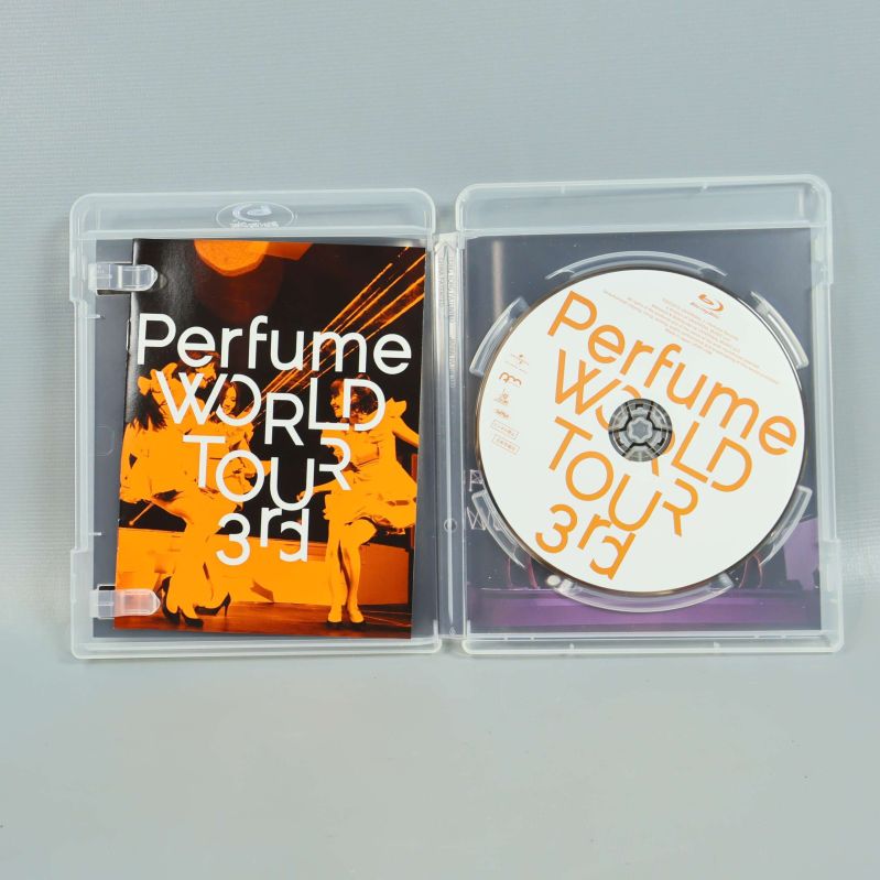 Blu-ray-fodral öppet med skiva och booklet för Perfume World Tour 3rd