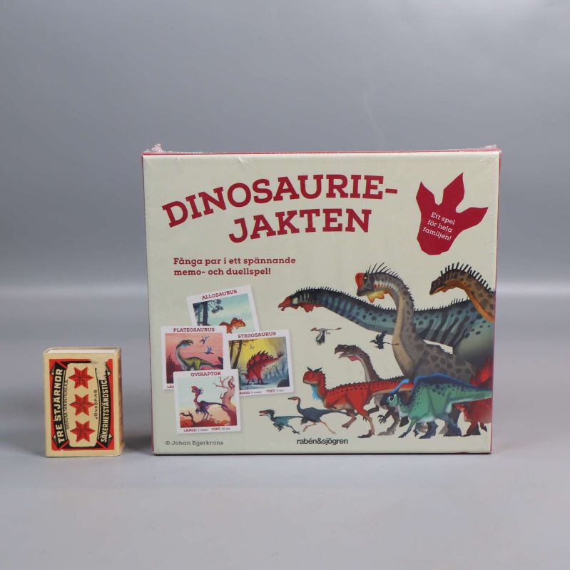 Spelboxen Dinosauriejakten bredvid en tändsticksask för storleksjämförelse