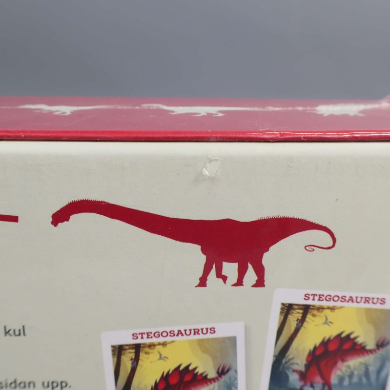 Närbild av röd dinosauriesiluett på boxen Dinosauriejakten