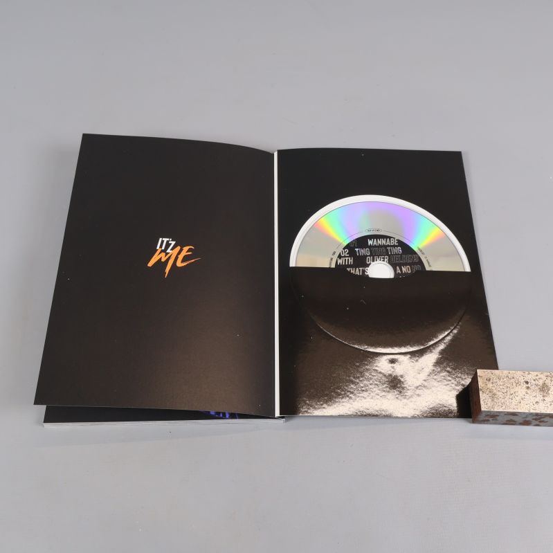 Album öppnat med CD-skiva i ficka och orange text
