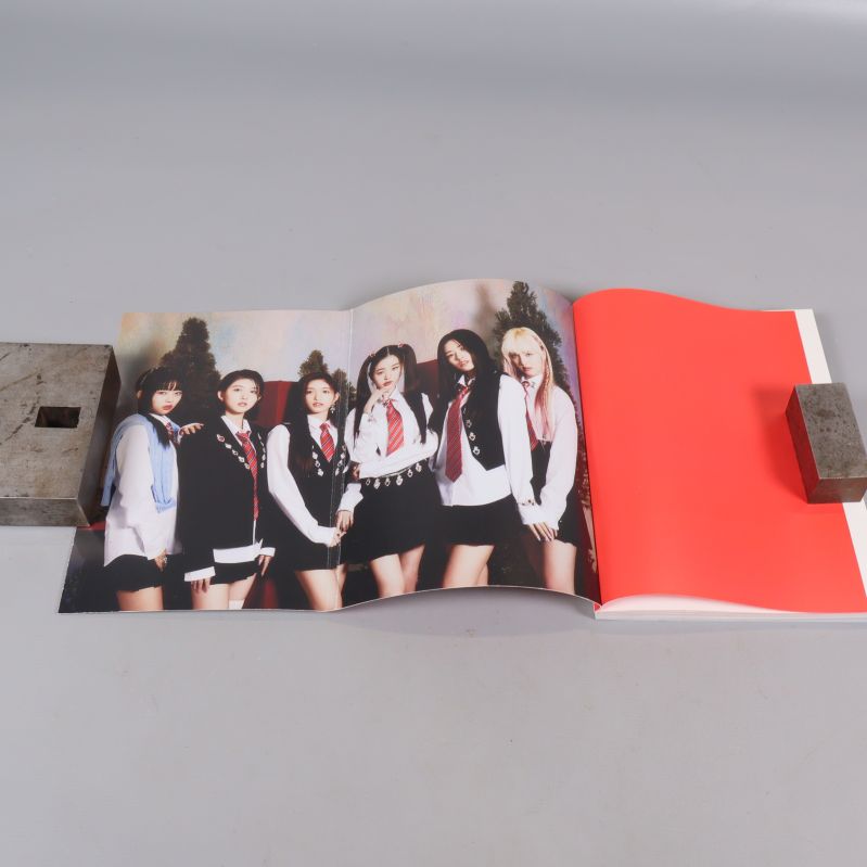 Uppslagen fotobok med färgbild på K-pop grupp