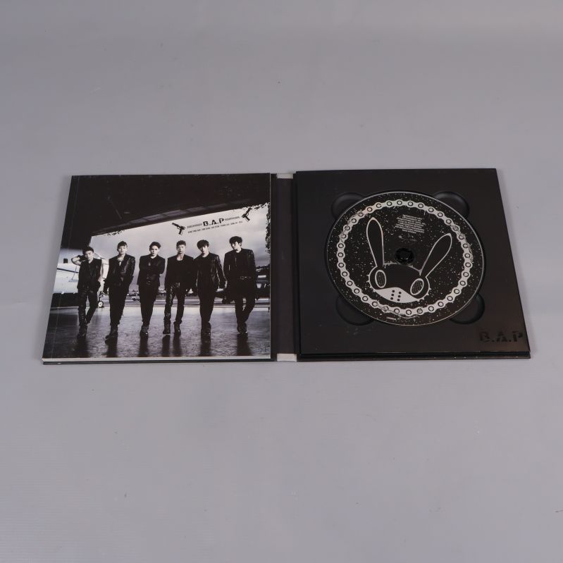 Uppslaget kpop-album visar cd och bandfoto
