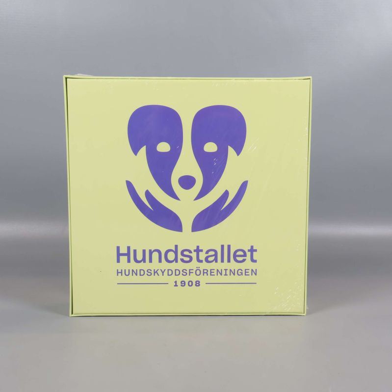 Baksidan visar Hundstallets logotyp och information
