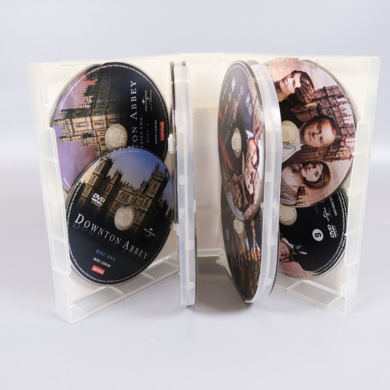 Öppnad Downton Abbey-box med innerskivor och seriekaraktärer på etiketten
