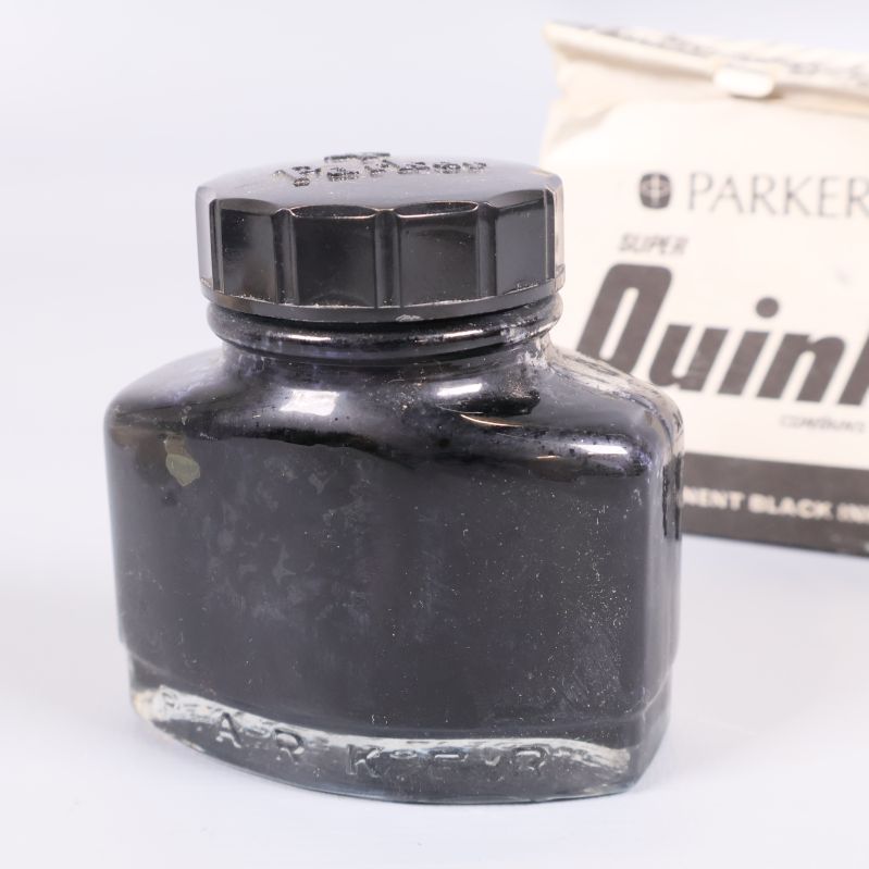 Svart bläckflaska nära originalförpackning från Parker Quink