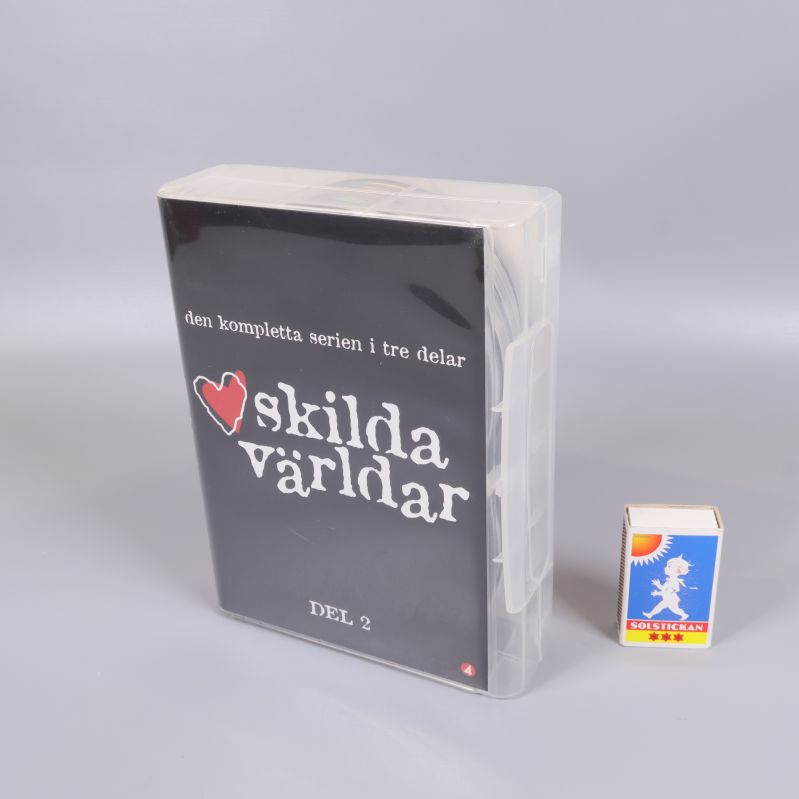 Dvd-box Skilda världar del 2 bredvid tändsticksask för storleksjämförelse