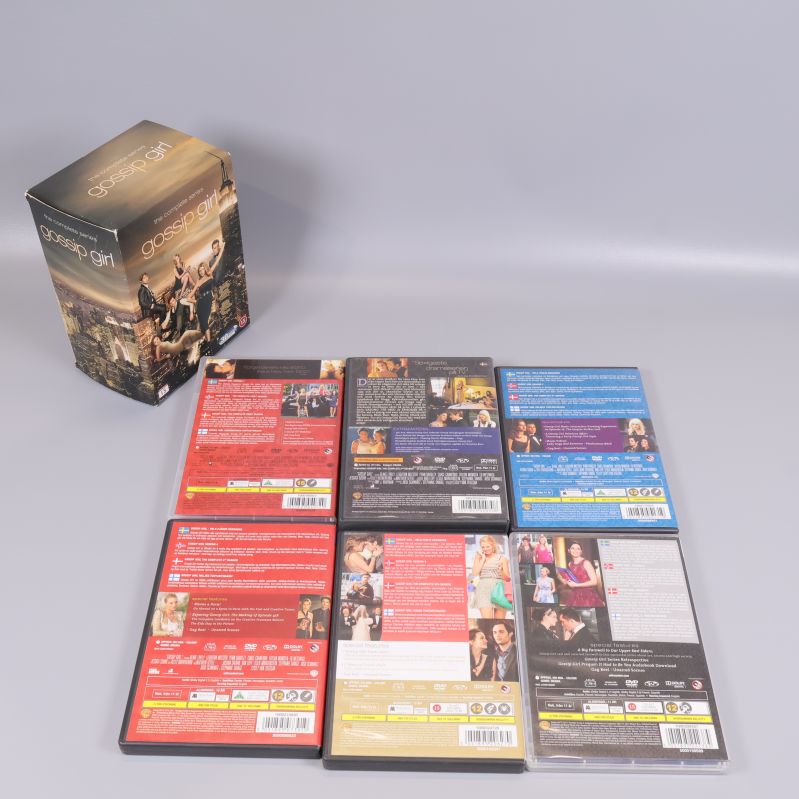 Baksidor på alla Gossip Girl DVD-fodral bredvid boxen