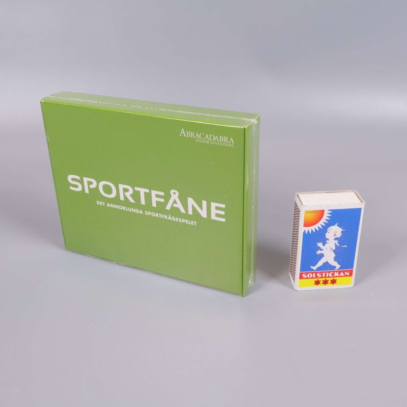 Sportfåne spelask bredvid tändsticksask för storleksreferens