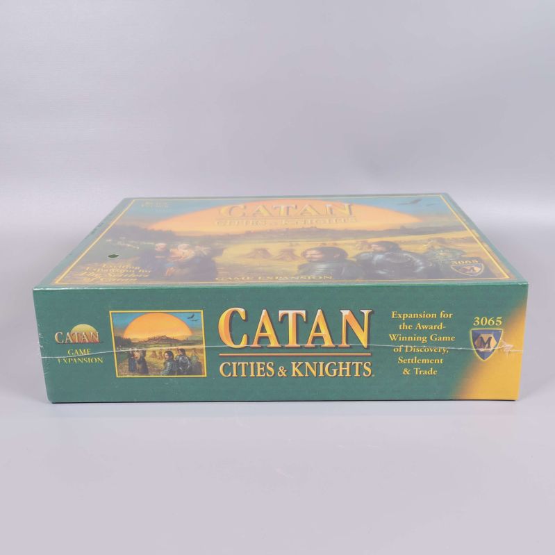 Långsida på Catan Cities & Knights expansionspaket med text och logotyp