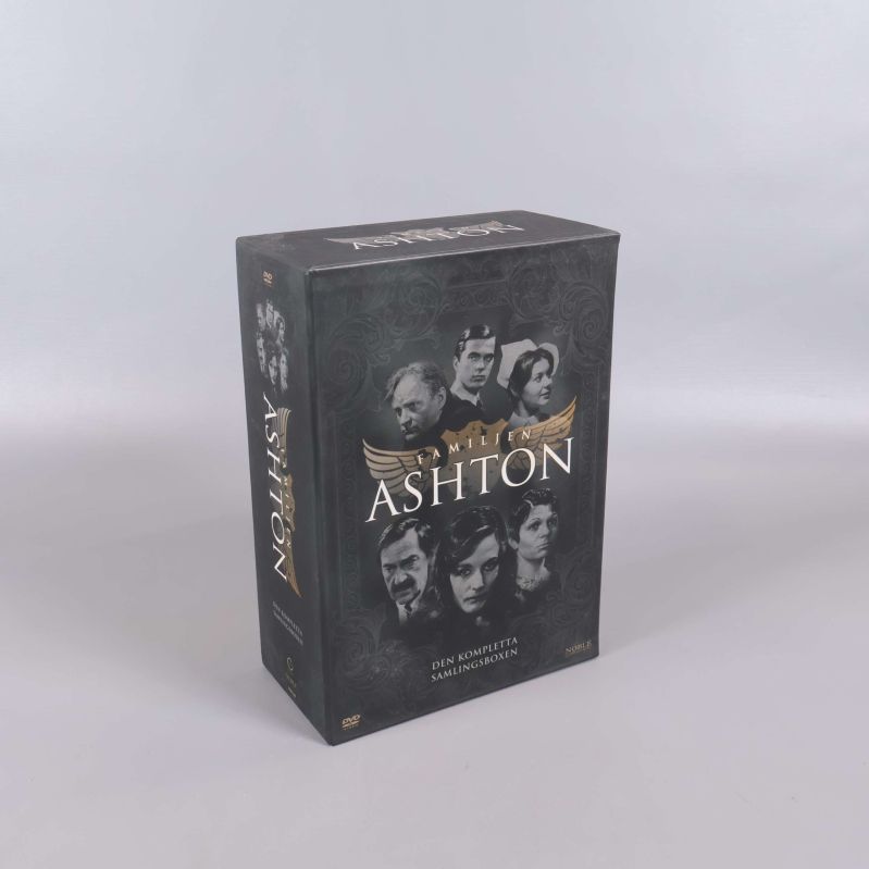 Familjen Ashton DVD-box ställd i vinkel med guldinslag och porträtt