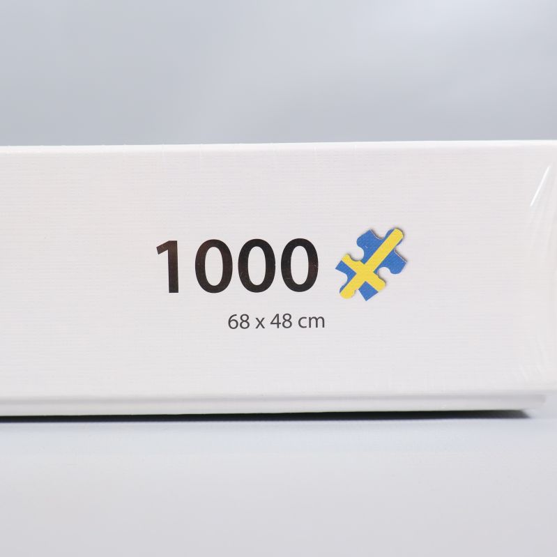 Närbild på 1000 bitar och måttangivelse på pusselbox