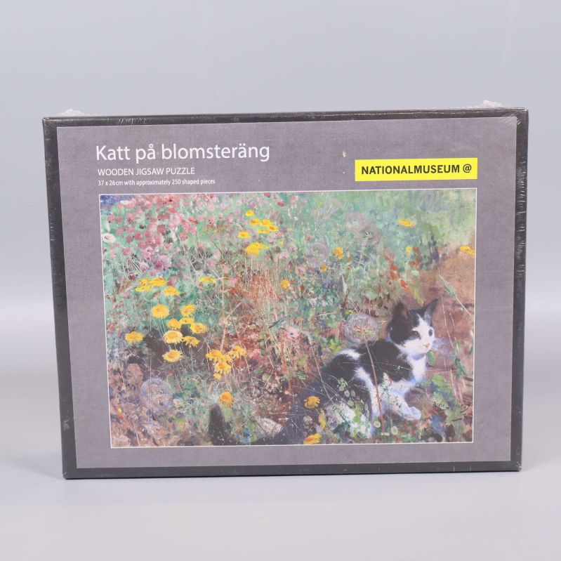 Framsida av träpusslets kartong med katt i blomsteräng