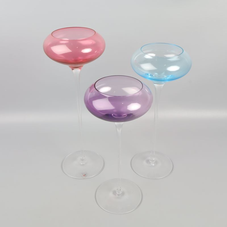 Tre färgade cocktailglas i olika färger