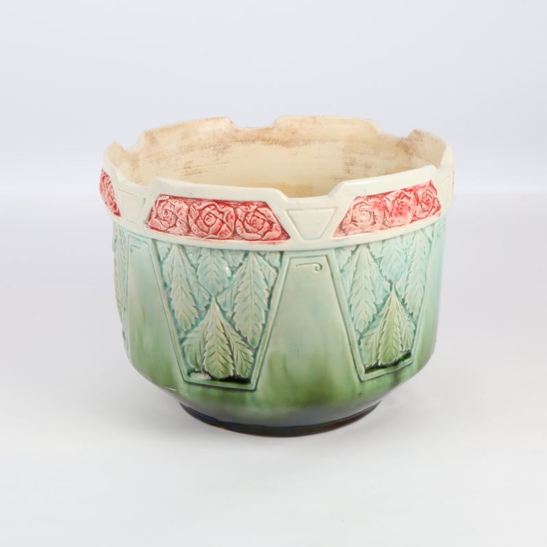 Grön kruka med blommönster och rosa detaljer