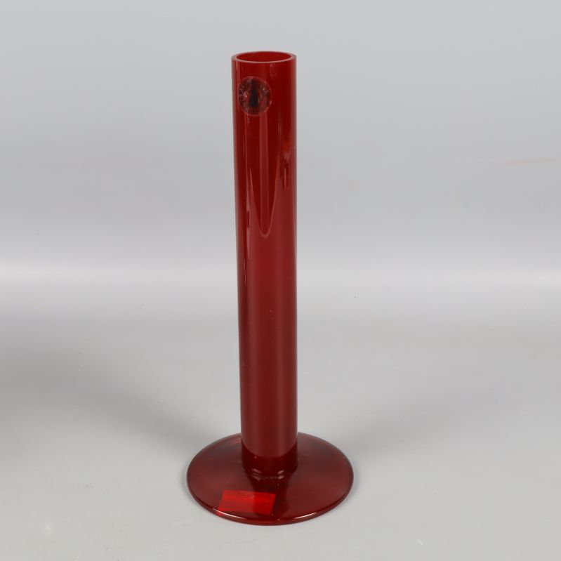 Smal röd glasvas stående