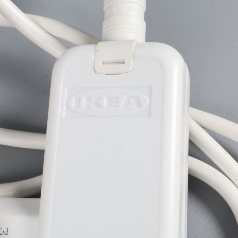 Närbild på vit IKEA adapter med logotyp