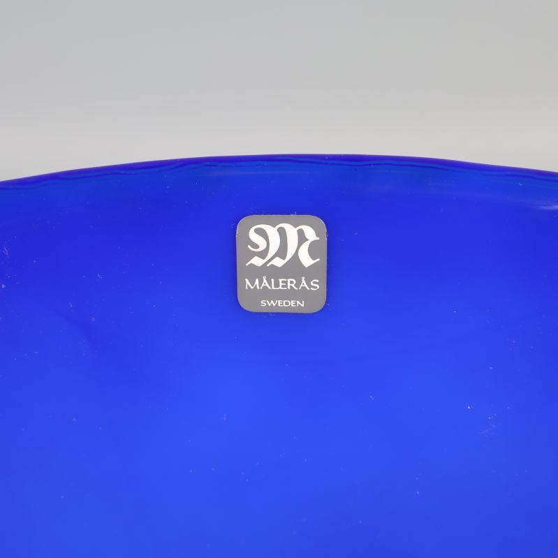 Närbild av Målerås logotyp på blå skål