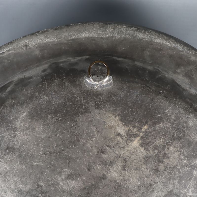 Baksida av metallbricka med liten ring