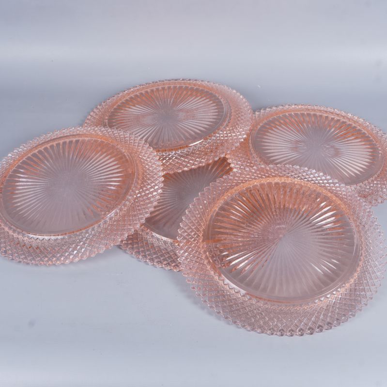 Fyra rosa glas­tallrikar lagda över varandra