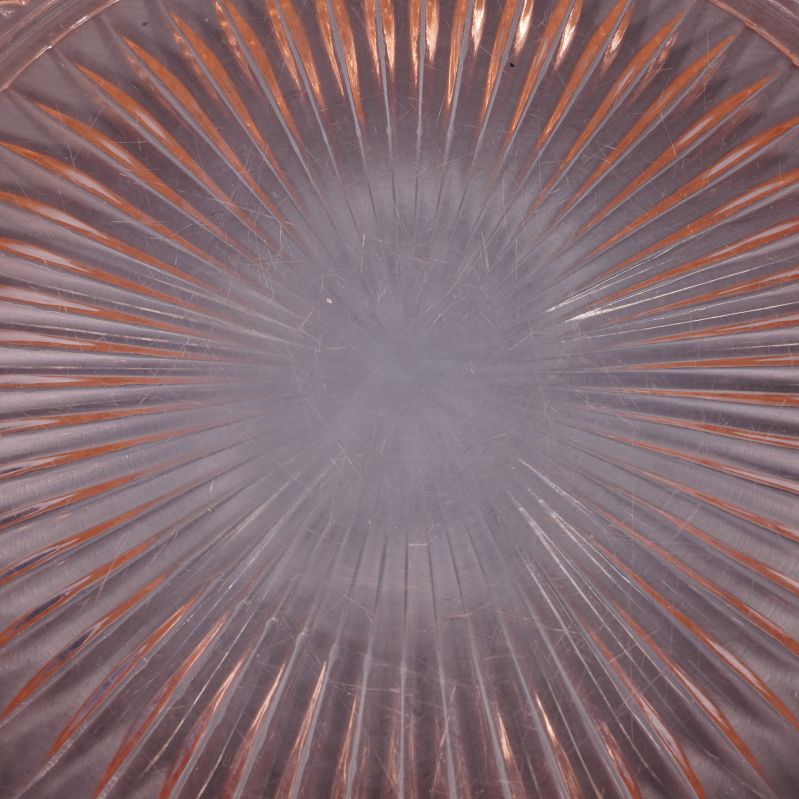 Detaljerat solstråle­mönster i mitten av tallrik, repor