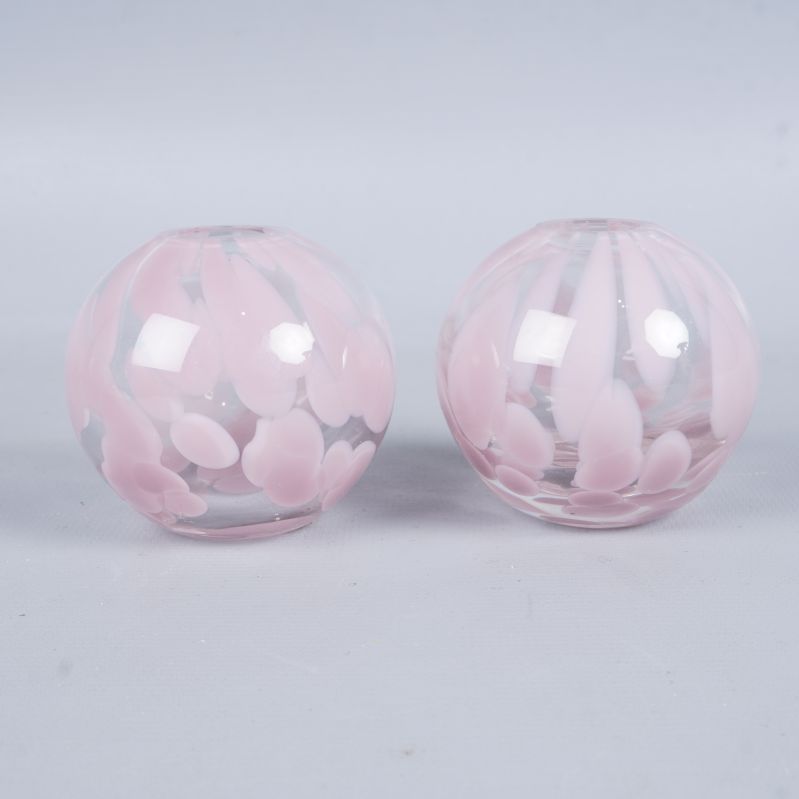 Framifrån vy av två runda vaser med rosa mönster