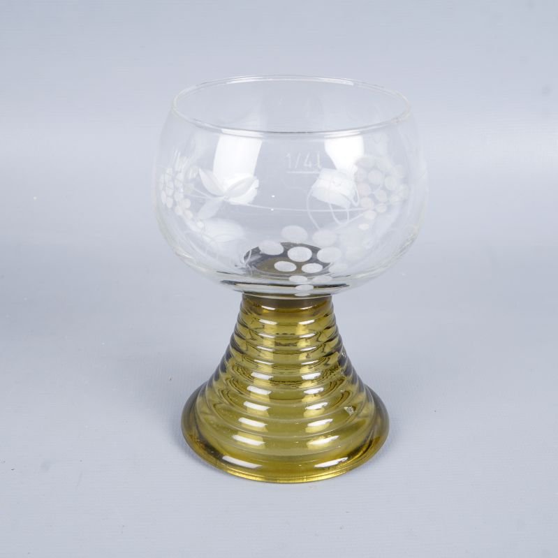 Ett vinglas med guldfärgat ben och graverat glas