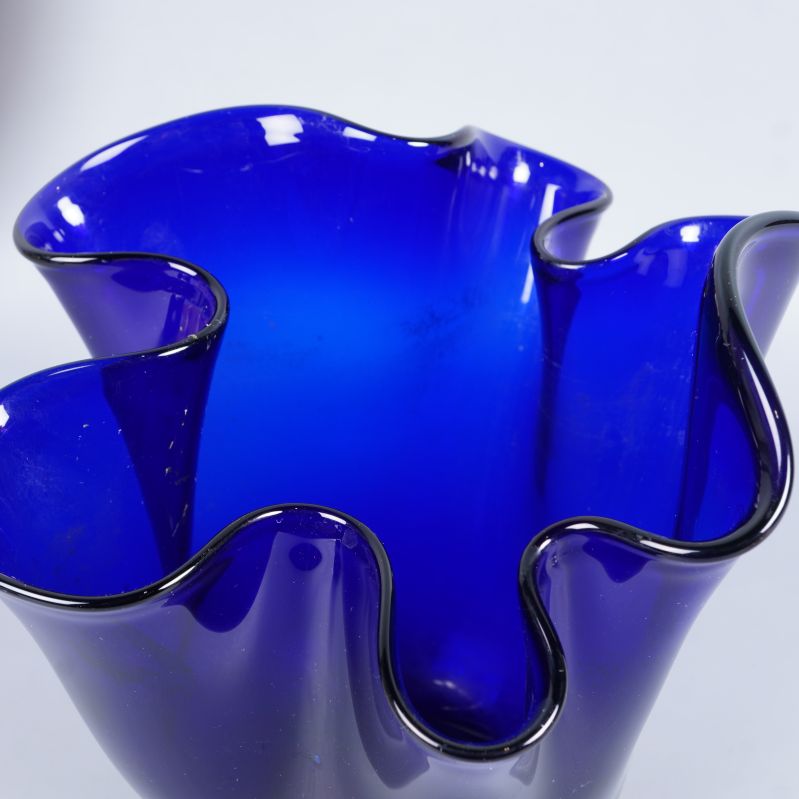 Närbild på vasens vågiga kant och blå färg