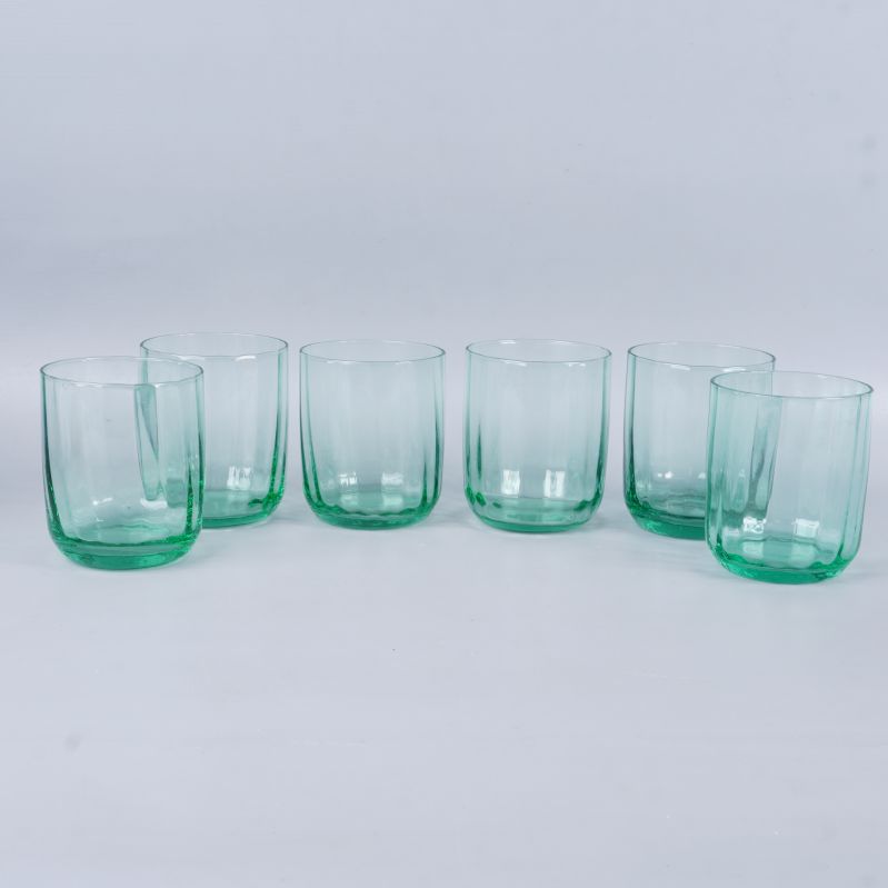 Sex gröna dricksglas uppradade mot vit bakgrund