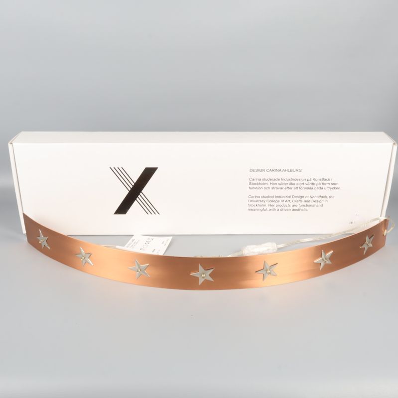 Böjd adventsljusstake med stjärnor och vit låda bakom