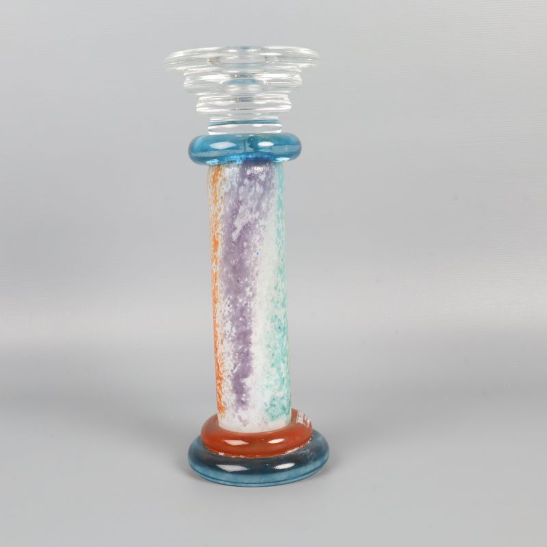 Ljusblå, gul och orange glasljusstake sedd från sidan