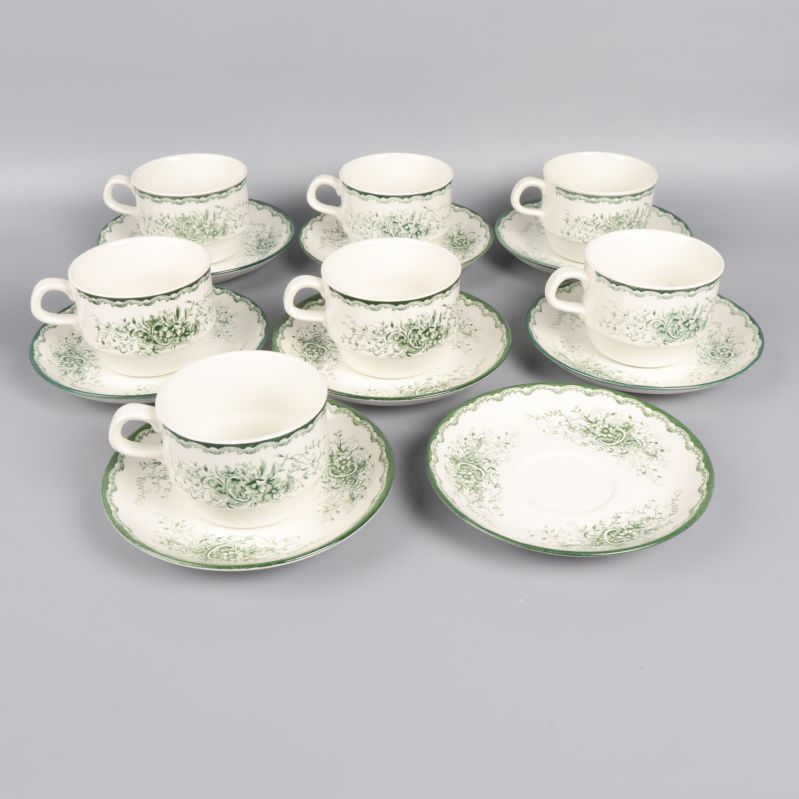 Sju koppar med fat dekorerade i grönt