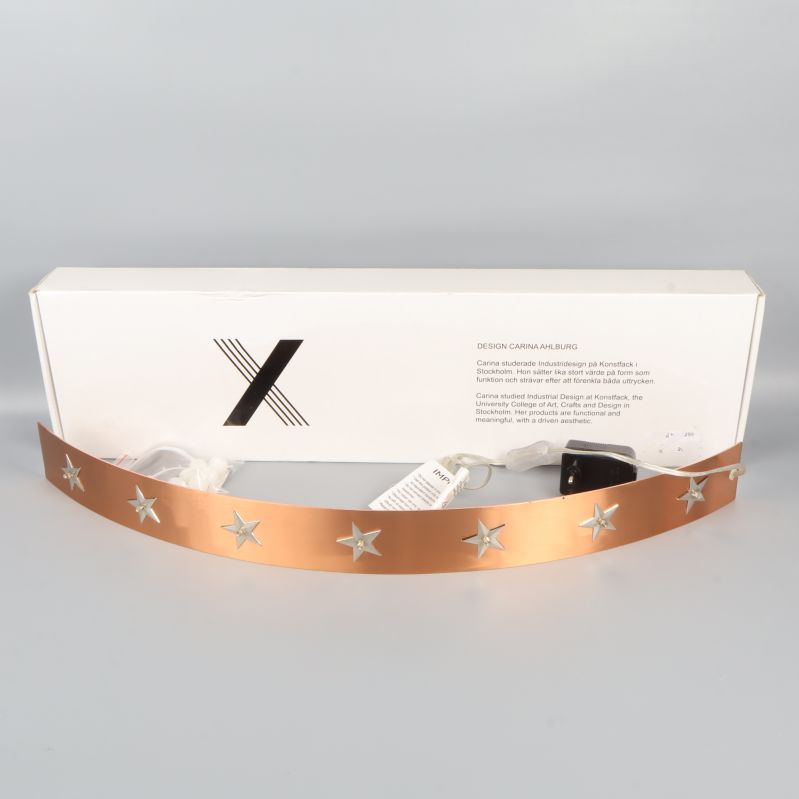 Bågformad ljusstake i bronsfärgad metall med stjärnmotiv