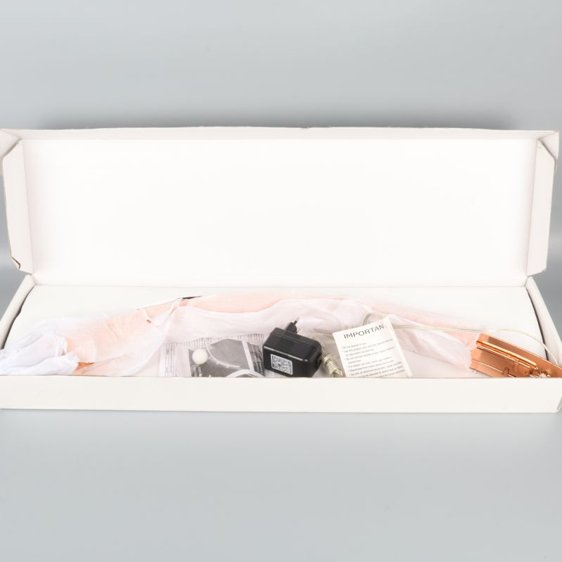 Vit kartong med ljusstake och tillbehör inuti förpackningen