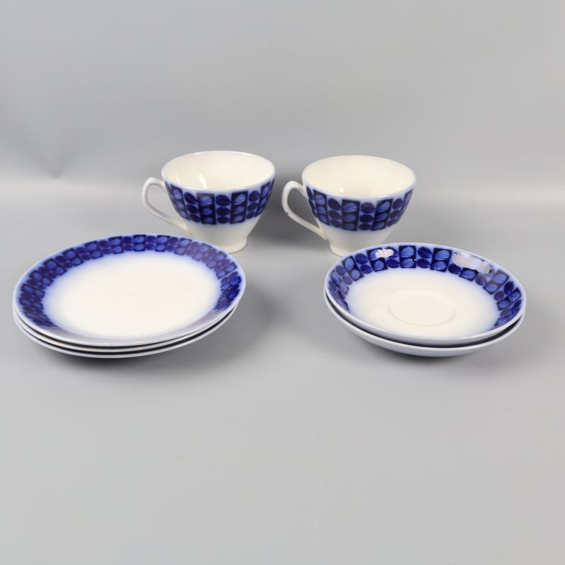 Tre porslinsassietter och två tekoppar med blå dekor
