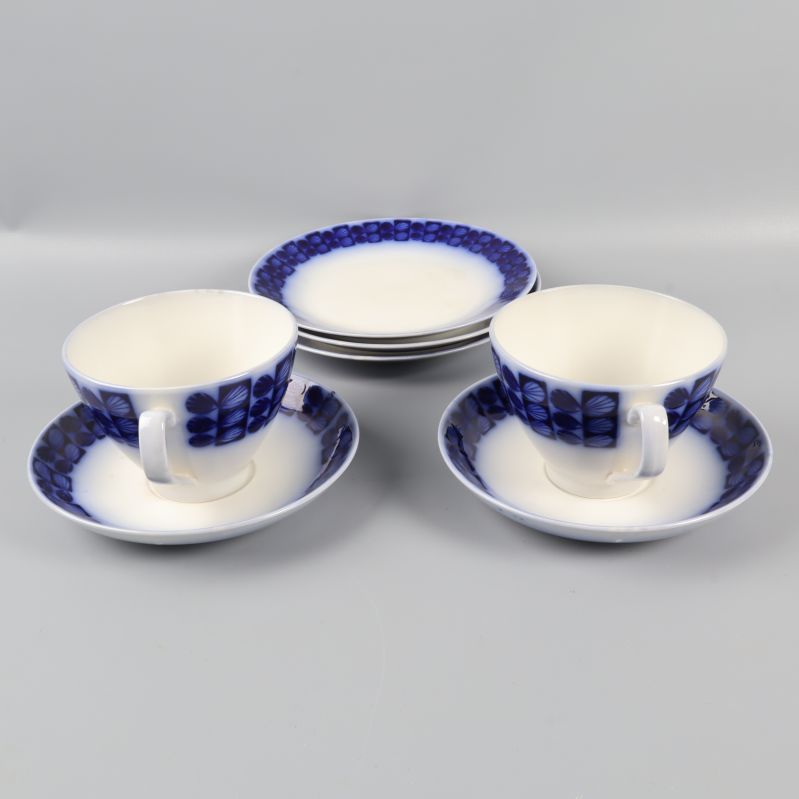 Två tekoppar med fat och tre assietter  med blå mönsterkant