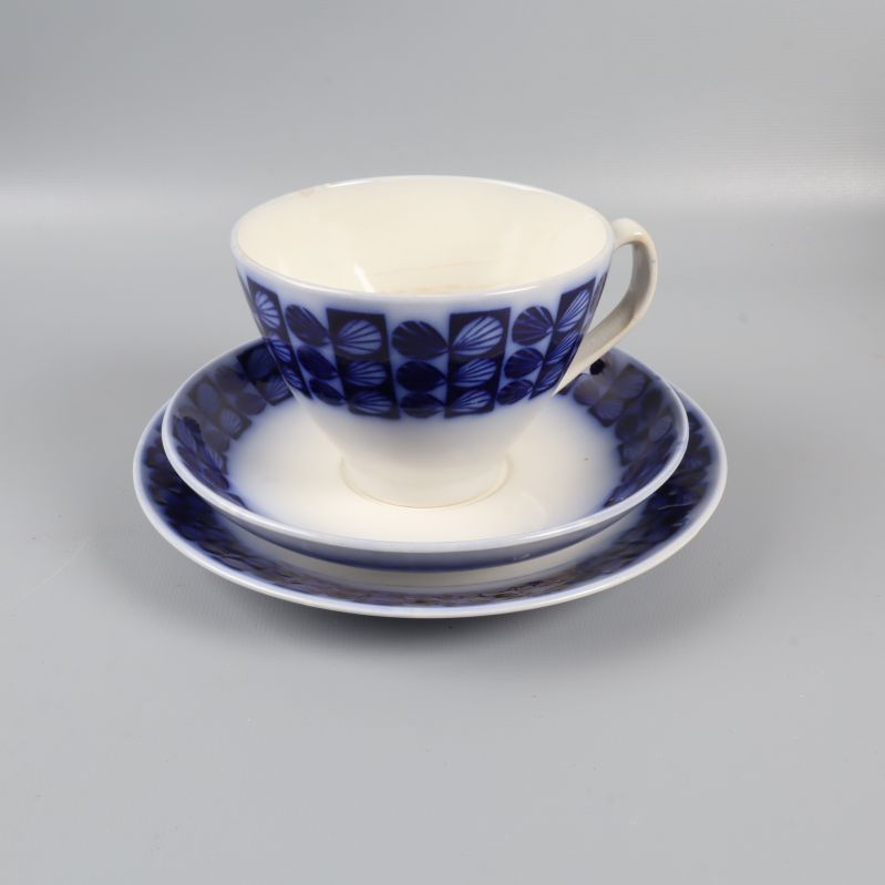 En kopp och fat med blå dekor mot grå bakgrund