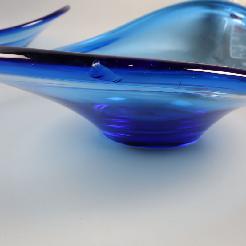 Närbild på en blå glasskål med liten kantdefekt