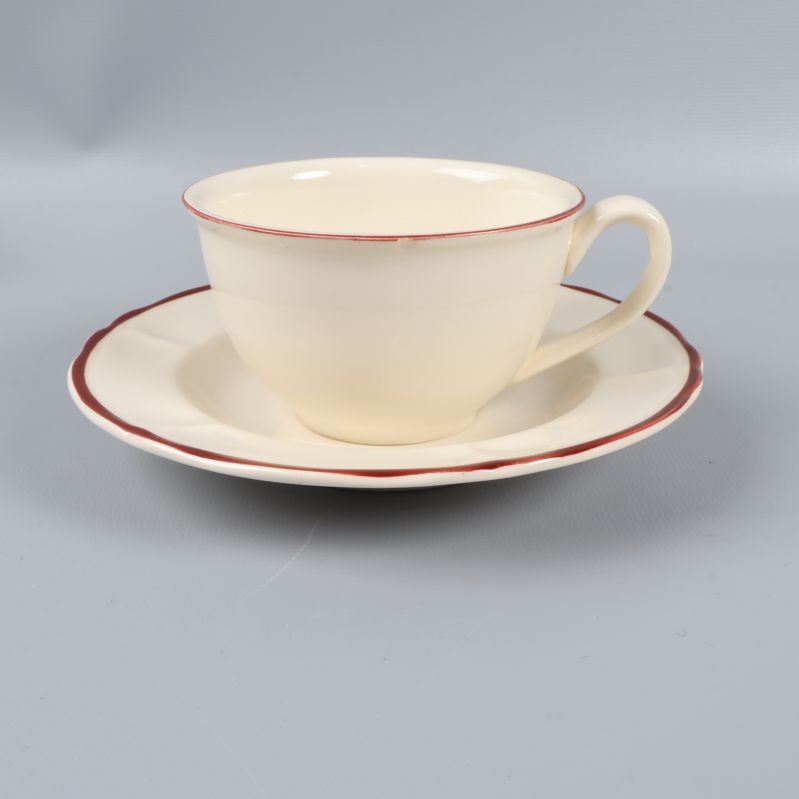 Kopp med fat i ljust porslin och röd kant