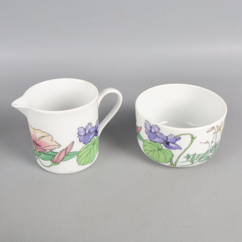 Gräddkanna och sockerskål med blommor och vita insidor