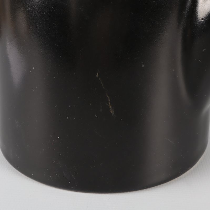 Närbild på liten repa på tekannans svarta yta