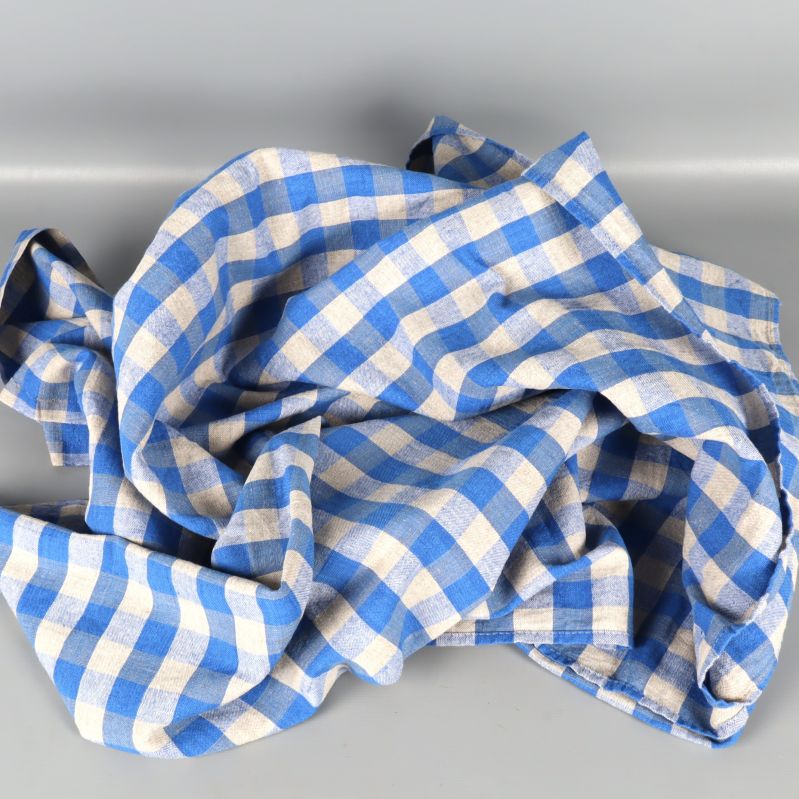 Krullad blå och beige rutmönstrad duk på ljus yta