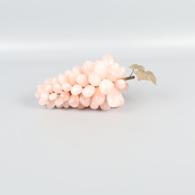 Pastellrosa dekorativ druvklase liggande på vit bakgrund