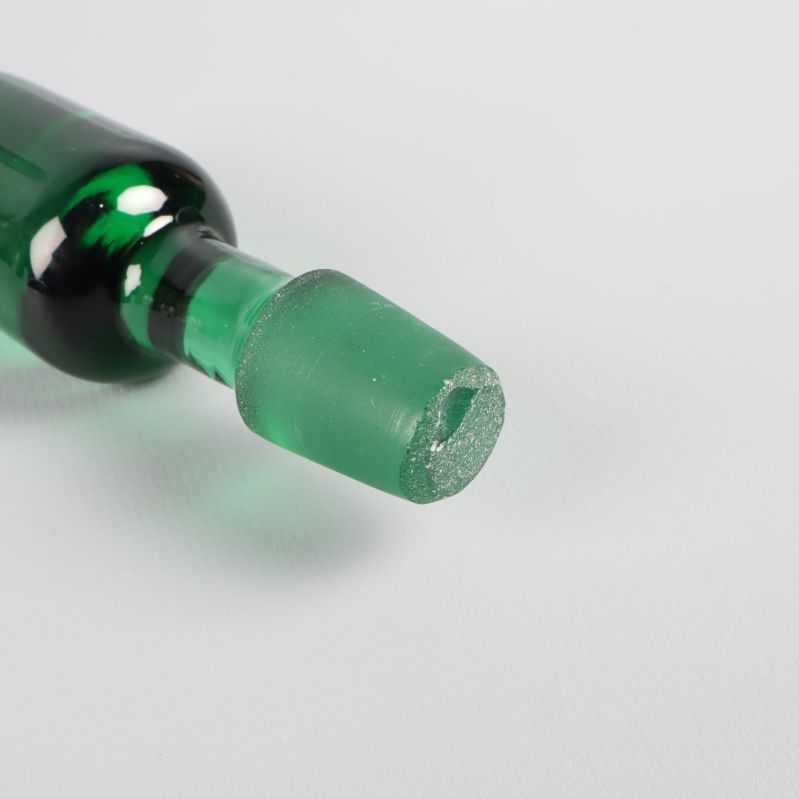 Närbild på grön glas knopp kantstött