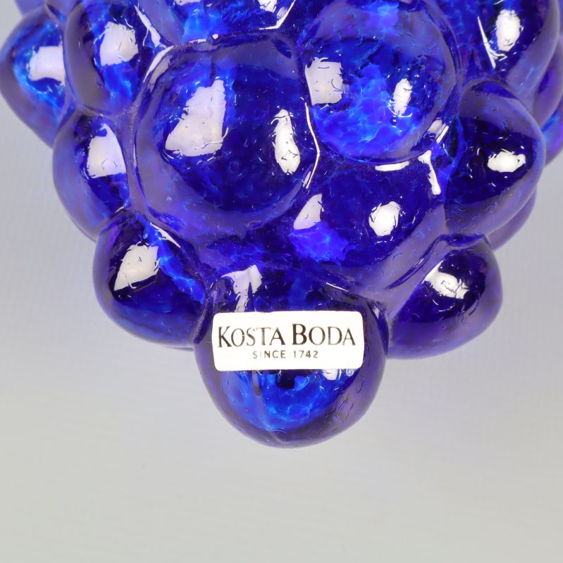 Närbild på Kosta Boda-logga på glasdruvan