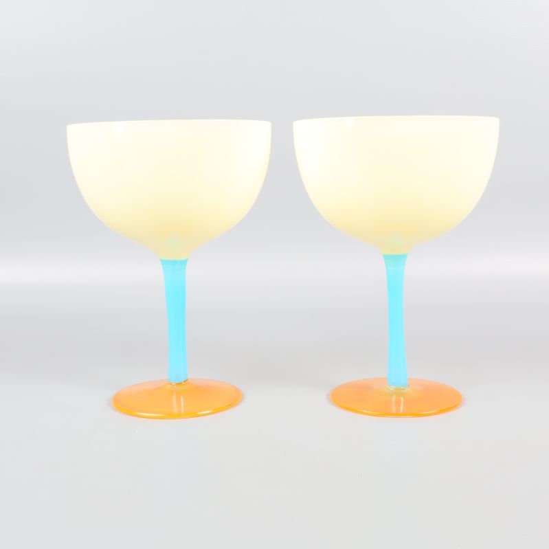 Framsida av två cocktailglas med blå fot och orange bas