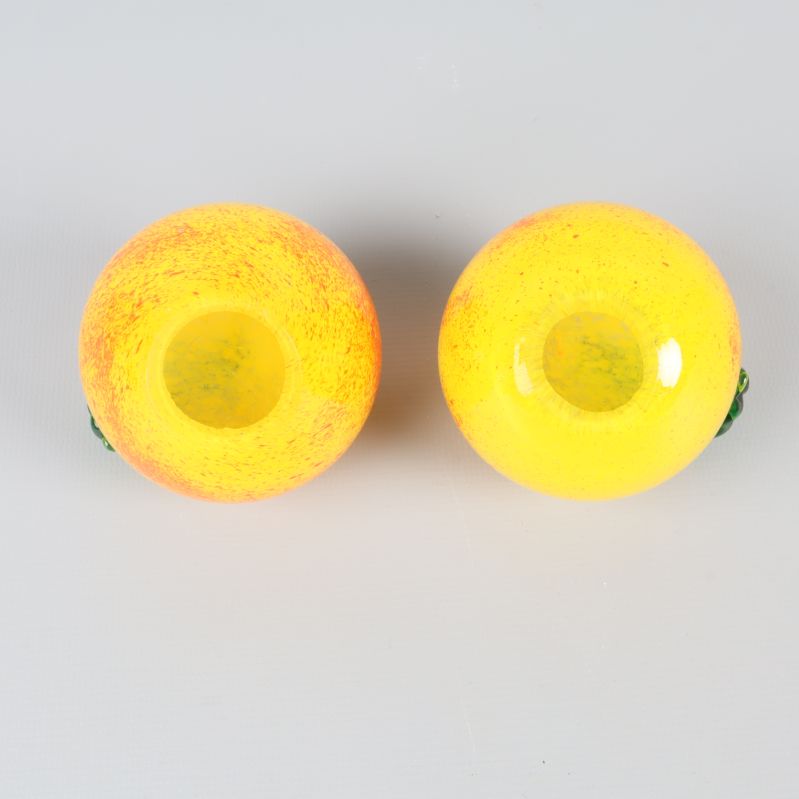 Undersida av två gula glasäpplen på rad